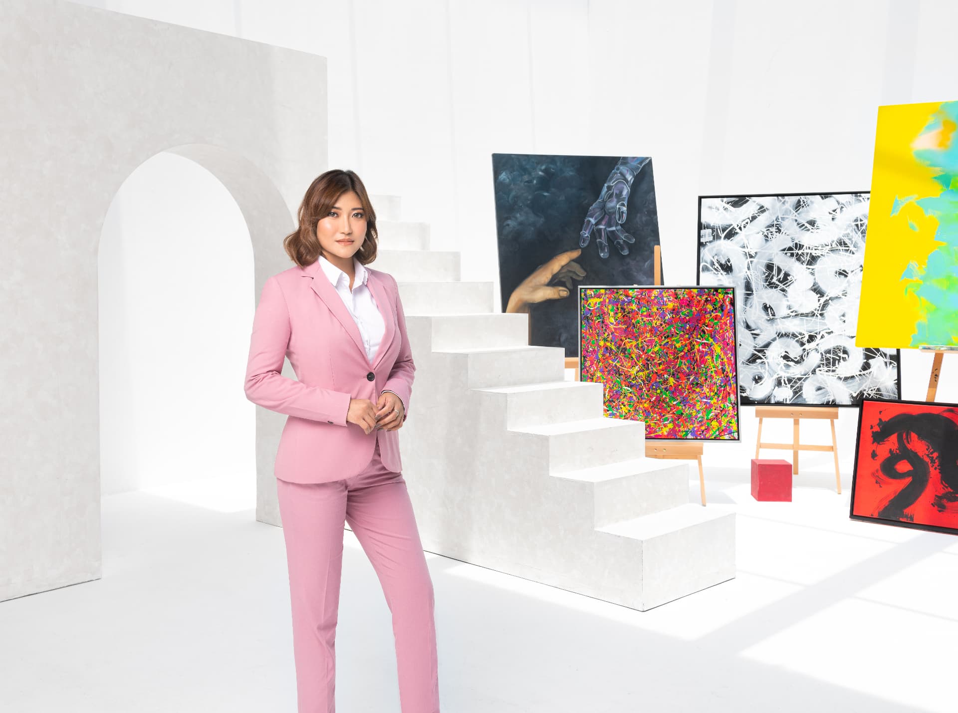 Romina May standing among her paintings on easels